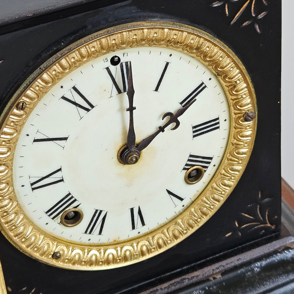 Close-up of an antique clock face with gold rim and Roman numerals.