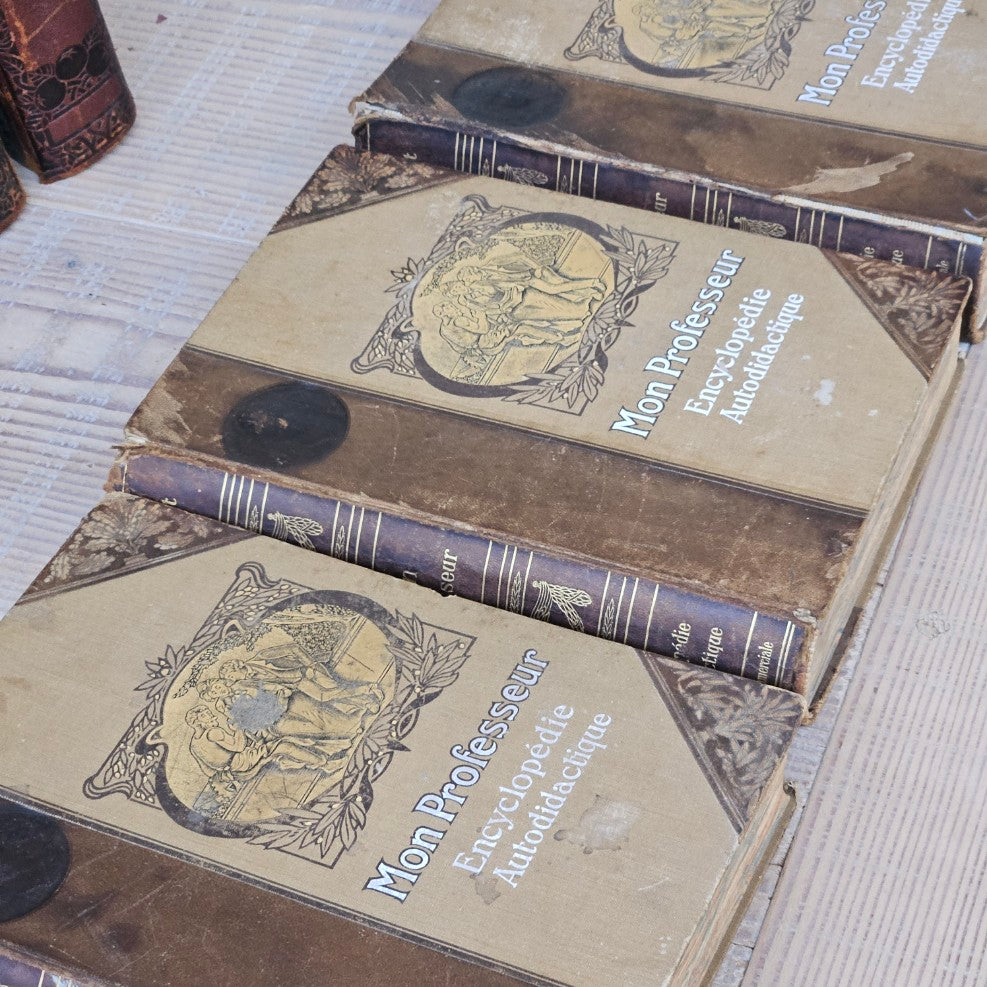 Stack of vintage books with decorative covers on a textured surface