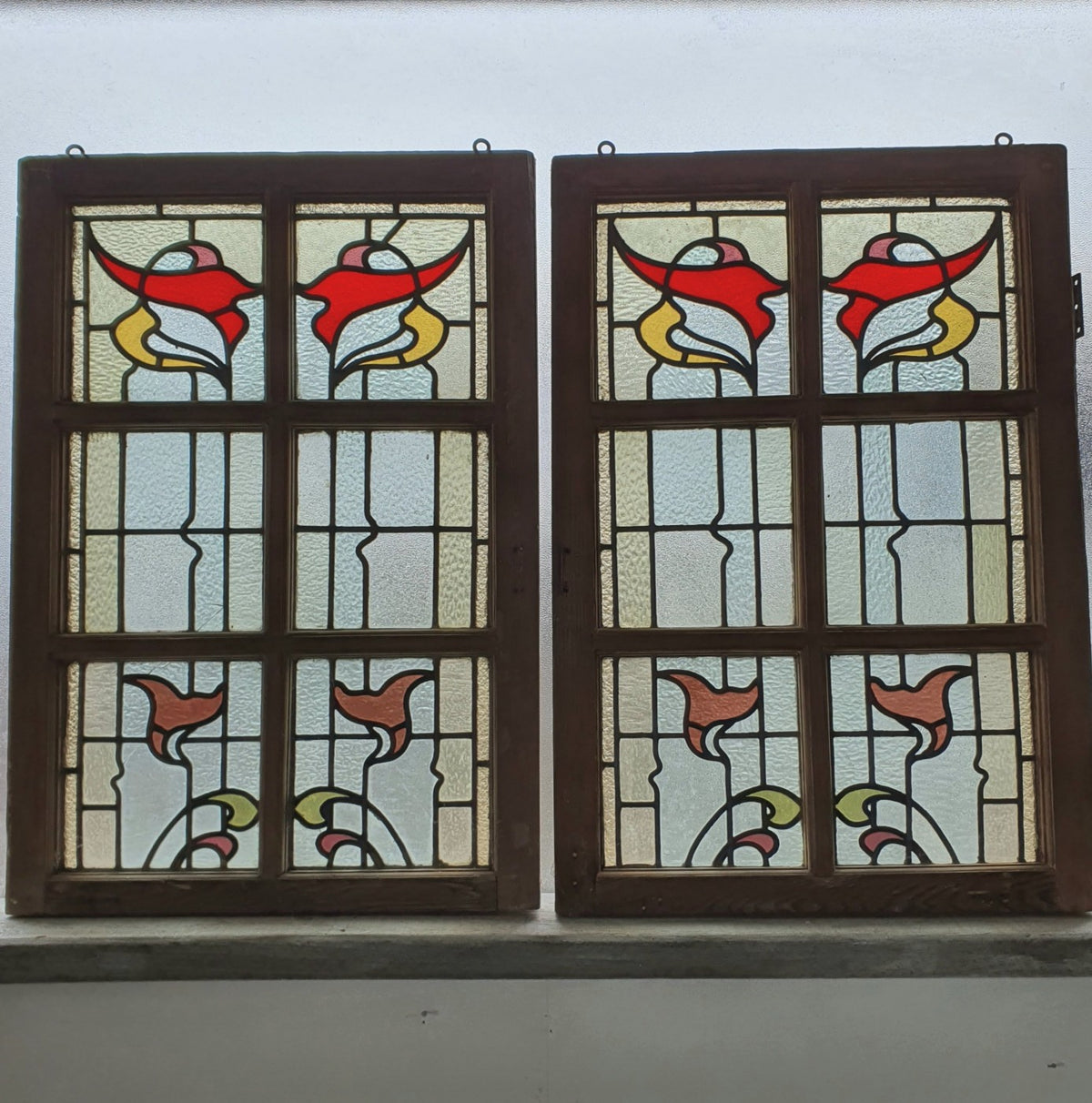 A pair of original multi-paned leadlight casement windows with redwood frame, stripped back to its bare state, ready for restoration or painting.